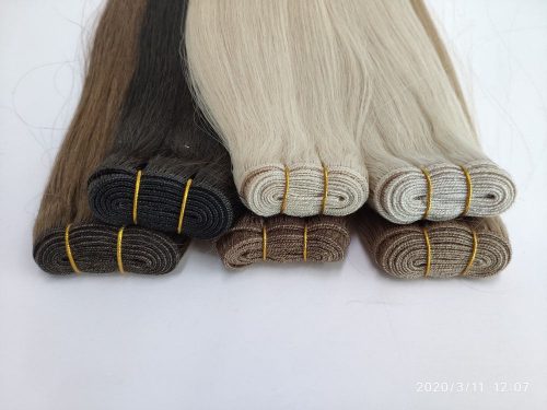 A group of different colored hair extensions sitting on top of each other.