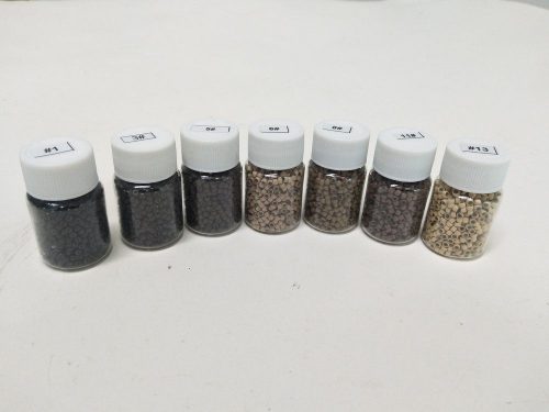 A row of different colored sand in jars.