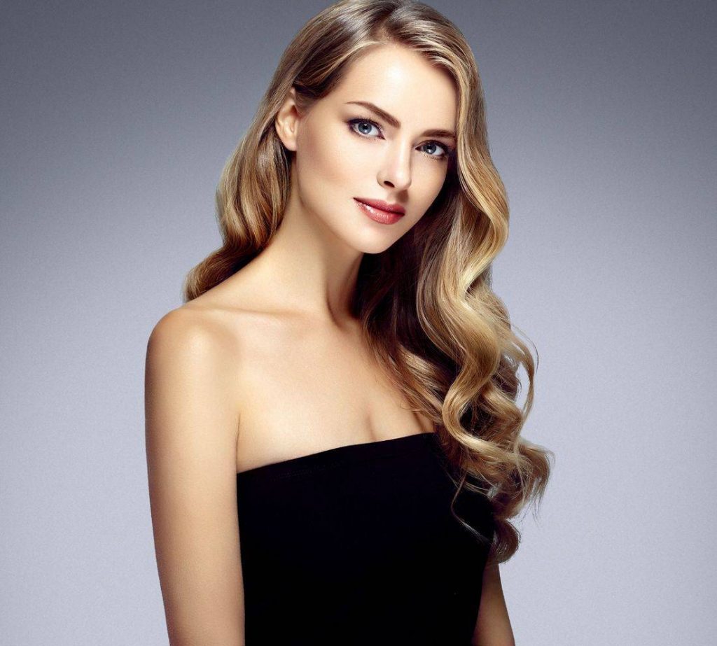 A woman with long blonde hair wearing black.